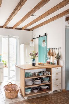 a kitchen filled with lots of dishes on top of a wooden counter next to a doorway