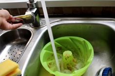 a person is washing their hands in the sink with soap and sponges on it