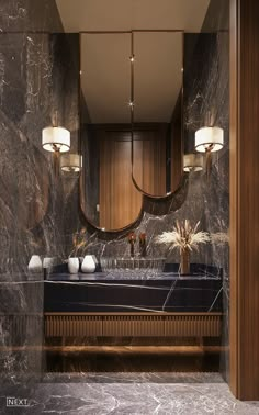 an elegant bathroom with marble walls and dark wood trimmings, along with two sinks