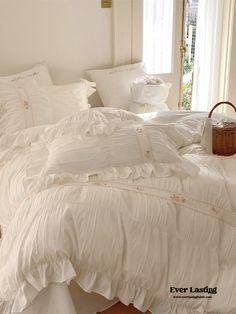 an unmade bed with white sheets and pillows