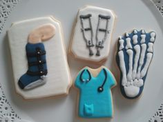 four decorated cookies on a white plate