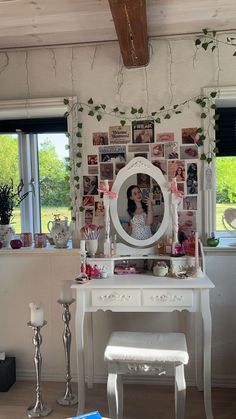 there is a white vanity with a mirror and pictures on the wall behind it in this room