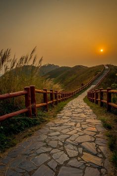 the sun is setting over an empty path