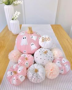 pink and white pumpkins are arranged on a table