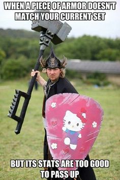 a man holding a giant hello kitty toy in his hand and wearing a helmet on top of it