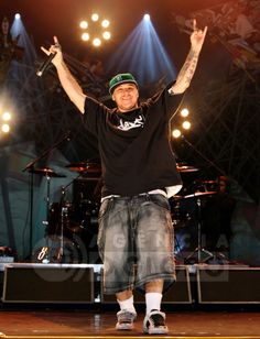 a man standing on top of a stage with his arms in the air