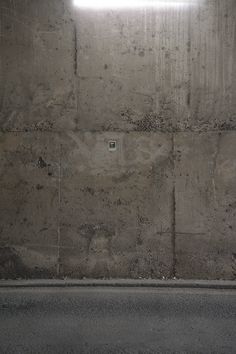 a white fire hydrant sitting on the side of a road next to a cement wall