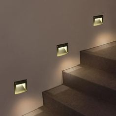 three lights on the wall above some stairs