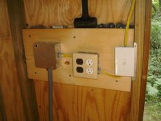 an electrical outlet is attached to the side of a wooden wall with wires and plugs