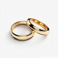 two gold wedding rings sitting on top of each other