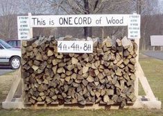 a pile of logs sitting in front of a sign that says this is one cord of wood