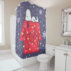 a bathroom with a shower curtain that has snoopy on it and snowflakes