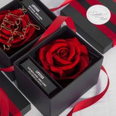 two black boxes with red ribbon and a single rose in the middle one is open