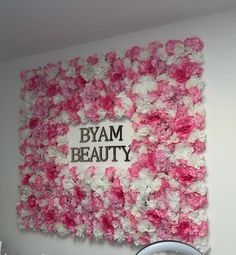 a pink and white flowered wall with the words byam beauty on it