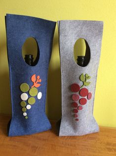 two vases made out of felt sitting on top of a wooden table next to each other