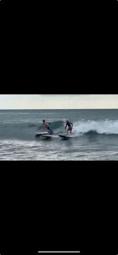 two people on surfboards riding waves in the ocean