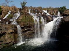 a large waterfall with water cascading down it's sides