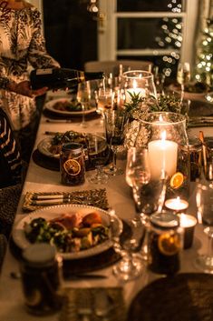 a long table is set with plates and candles