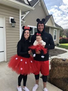 a man and woman are dressed up as mickey mouse and minnie mouse with their baby