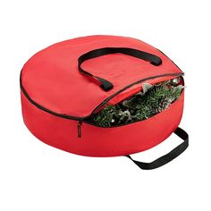 a red round bag filled with plants on top of a white background