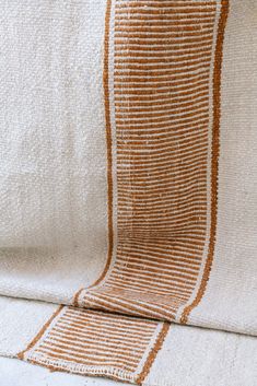 an orange and white striped blanket sitting on top of a couch