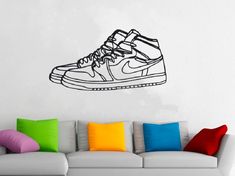 a living room with a couch and a wall decal that has a shoe on it