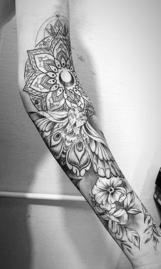 a black and white photo of a person's arm with flowers on it