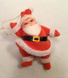 a santa clause ornament hanging from a gold chain