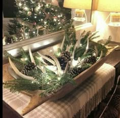 a wooden tray filled with antlers and pine cones on top of a dining room table