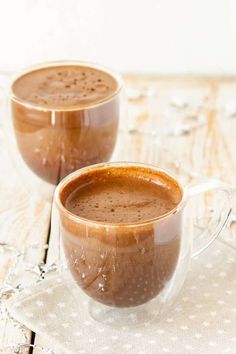 two mugs of hot chocolate on a wooden table