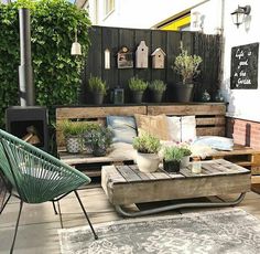 an outdoor living area with wooden pallets and potted plants