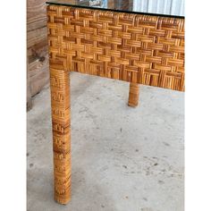 a wooden table with glass top sitting on concrete