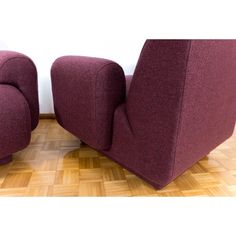 two purple chairs sitting next to each other on a wooden floor