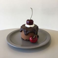 there is a chocolate cupcake with a cherry on top and whipped cream on the top