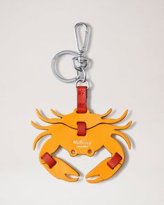 a yellow crab shaped keychain with red straps