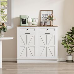 a white cabinet sitting next to a potted plant