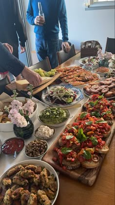 people standing around a table full of food