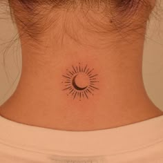 a woman's neck with a small sun and moon tattoo on the back of her neck