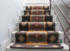 the carpeted stairs are decorated with red, white and brown rugs on them