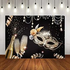 a black and gold masquerade backdrop with two champagne flutes on the floor in front of it