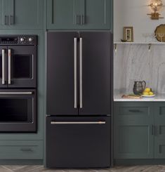 a kitchen with green cabinets and an oven in the center, along with marble counter tops