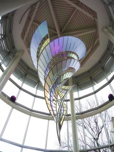 the inside of a circular building with many windows and spiral designs on it's ceiling