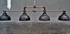 three lights are hanging from a metal bar