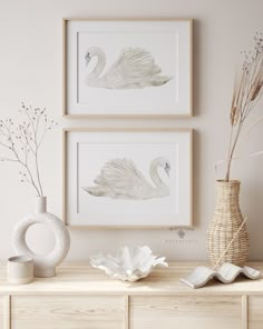 two white swans are on the wall above a dresser