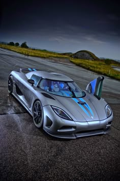 a silver sports car parked on top of a tarmac