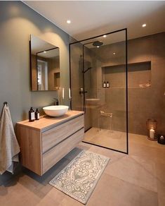 a bathroom with a sink, mirror and shower stall