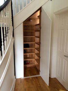 an open closet in the corner of a staircase