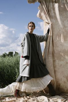 a woman is standing next to a curtain