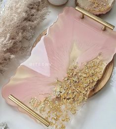 a pink and gold plate sitting on top of a table next to some other items