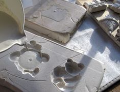 a person pouring cement into a bowl on top of a table next to other items